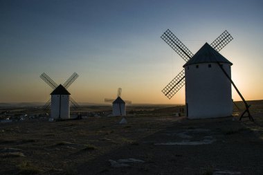 Bir gün Castilla La Mancha 'da gün batımında yel değirmeni.