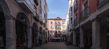 Şehrin tarihi merkezinde, Burgos, İspanya 'da renkli binaları olan yayalar var.