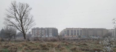 İspanya 'nın Burgos şehrinde bulutlu bir günde kuru çimen tarlasından modern konut manzarası