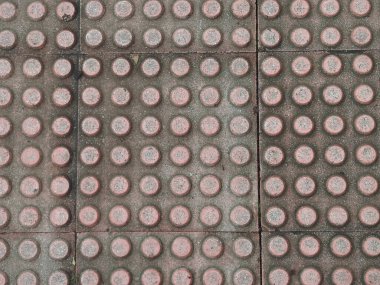 Görme engelli insanların yönelimi için kırmızı dokunsal döşeme taşlarının havadan görünüşü