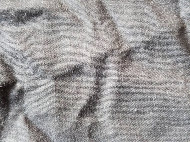 Pürüzsüz yüzeyi ve görünür lifleri olan kırışık gri kumaş dokunun arka planı