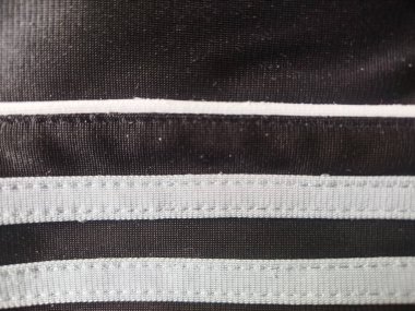 Siyah spor kumaşına dikilmiş yatay beyaz çizgilerin ayrıntıları