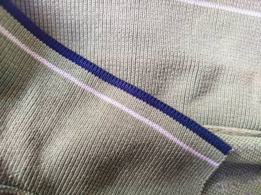 Mavi ve beyaz çizgili yeşil kurdeleli kumaş.