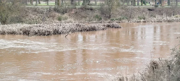 İspanya, Burgos kıyılarında bulanık su ve kuru bitki örtüsüyle hızlı akan bir nehir.