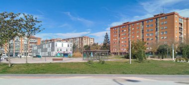 İspanya, Burgos 'ta mavi gökyüzü altında yeşil alanları ve tuğlalı binaları olan panoramik bir yerleşim yeri manzarası