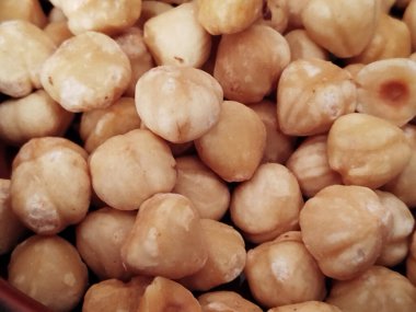 Doğal dokuları olan soyulmuş ve kavrulmuş fındıklara yakın plan.