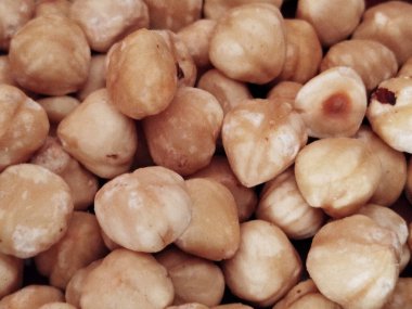 Doğal dokuları olan soyulmuş ve kavrulmuş fındıklara yakın plan.