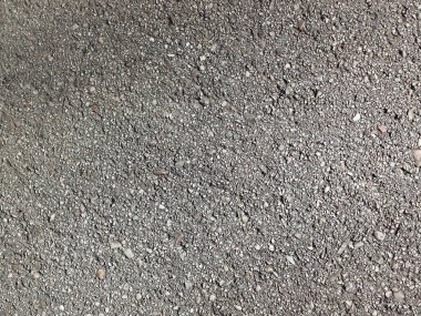 Küçük kümeler ve mineral taneleriyle gri asfalt yüzey dokusu
