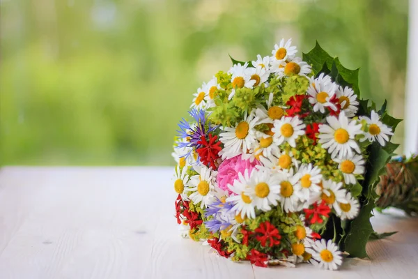 Beautiful wild summer flowers bouquet on the open book with green background — Stock Photo, Image