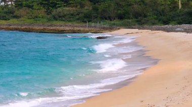 Gözlerin önündeki ark plajında, sürekli dalgalar. Resimli deniz manzarası ve manzaralı sarı kum manzarası, engin deniz püskürtüsü. Muhteşem bir turizm merkezi oluşturun. Kenting Ulusal Parkı, Tayvan