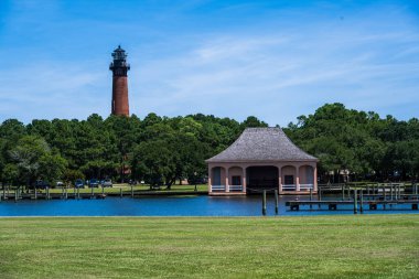 Corolla Park 'taki göldeki bir kayıkhanenin fotoğrafı. Arkasında Currituck Sahili Deniz Feneri var..