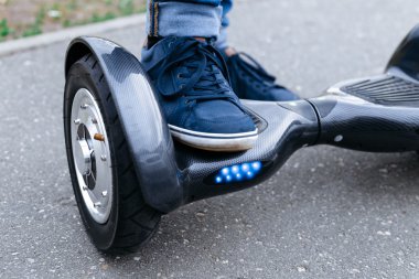 Mavi spor ayakkabı ve sokaklar mavi gyroscooter platformda ayakta kot pantolon bacak erkekler. Elektrikli scooter, hoverboard, gyroboard veya gyroscooter kullanmaya başlayın.