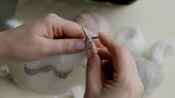 Frauenhände aus nächster Nähe: ein Strickprodukt aus Wolle in der Farbe Sail Champagne mit einem grau-pudrigen Farbton. — Stockvideo