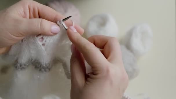 Primo piano delle mani delle donne: un prodotto lavorato a maglia di lana nel colore della vela Champagne con una tonalità grigia e polverosa. — Video Stock