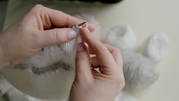 Primo piano delle mani delle donne: un prodotto lavorato a maglia di lana nel colore della vela Champagne con una tonalità grigia e polverosa. — Video Stock