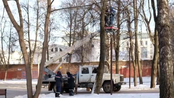 Nischni Nowgorod Russland-Dezember 2020: Arbeiter schmücken im Winter einen Stadtpark: Sie hängen Weihnachtslichter an Bäume. — Stockvideo