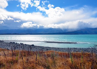 Lake Pukaki, Yeni Zelanda çevreleyen dağların üzerinden haddeleme bulutlar