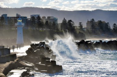 Büyük dalgalar breaking Wollongong liman breakwall ve deniz feneri üzerinde