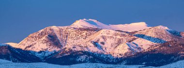 Dağ 'ın havadan görünüşü. Rose, Nevada, ABD, karla kaplı bir dağ manzarası sergiliyor. Sierra Nevada 'nın bir parçası olan zirveler açık mavi gökyüzü tarafından vurgulanır. Dağlık araziyi kar kaplıyor.