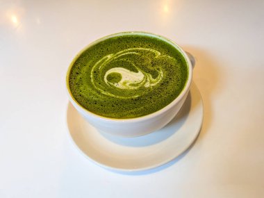 Yeşil kibrit içeceği beyaz masaya karşı.