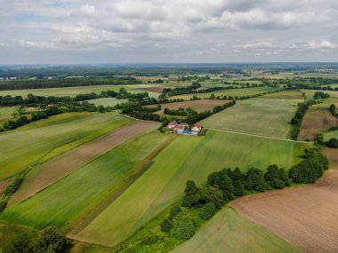 Yeşil alanlar arasında küçük bir Polonya köyünün üzerindeki karanlık ve atmosferik gökyüzünün havadan görünüşü. Yüksek kalite fotoğraf