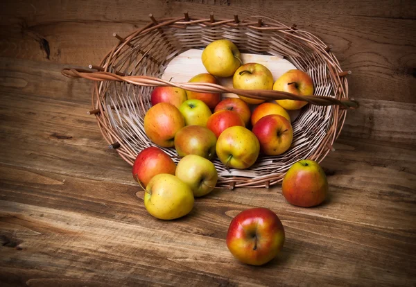 Apples in basket on wooden background — Stock Photo, Image