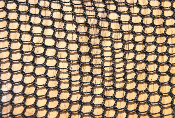 Closeup of netting on wood