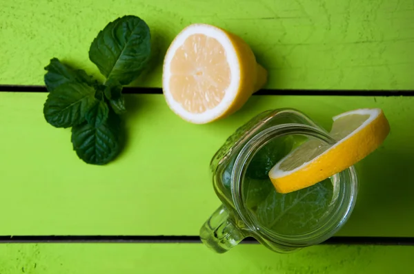 Glass of cold water with fresh mint leaves and lemon — Stock Photo, Image