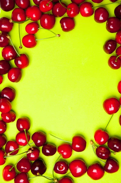 Cerises douces rouges sur fond vert — Photo