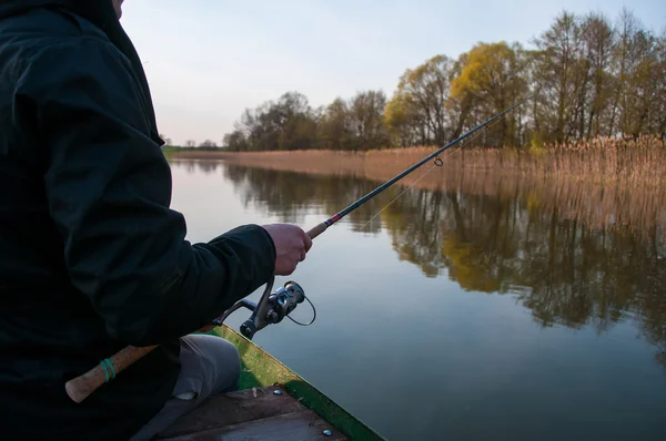 Fiskaren gjutning ett fiskespö från båt — Stockfoto