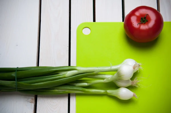 Sayuran di papan potong hijau, kayu latar belakang putih — Stok Foto