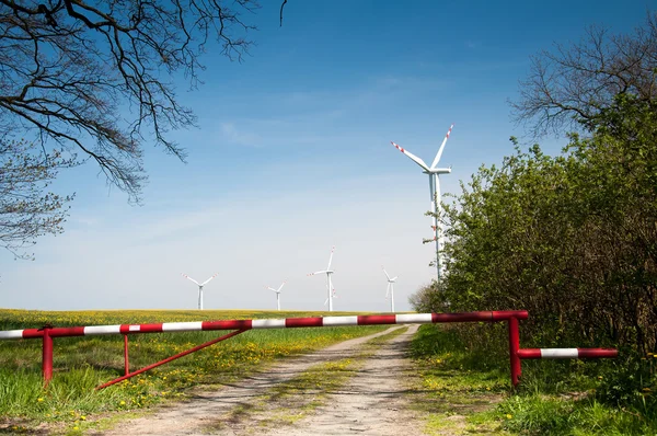 Turbina eólica detrás de la barrera y árboles — Foto de Stock