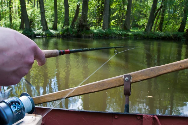 Hand som håller ett fiskespö med rulle — Stockfoto