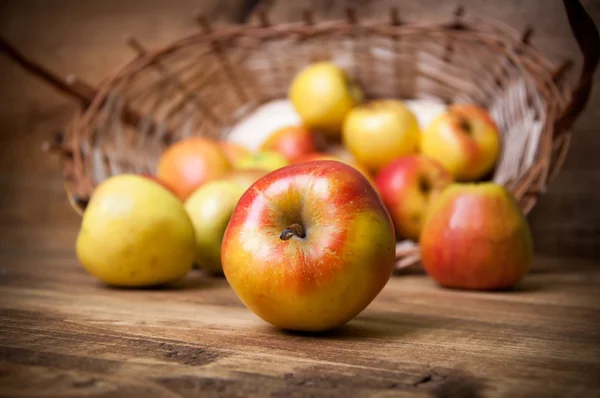 Korb mit Äpfeln auf Holzgrund — Stockfoto