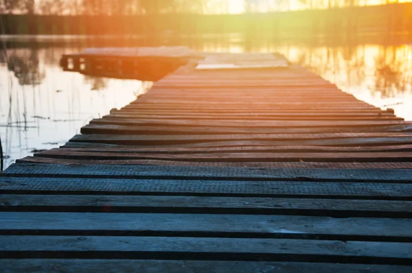 Jetty de madeira no lago sob o por do sol — Fotografia de Stock