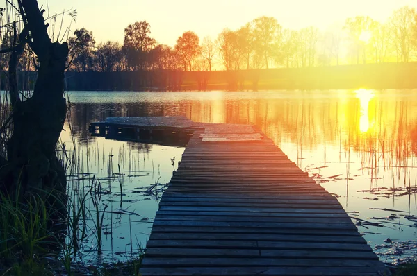 夕阳下的湖面上的木码头 — 图库照片