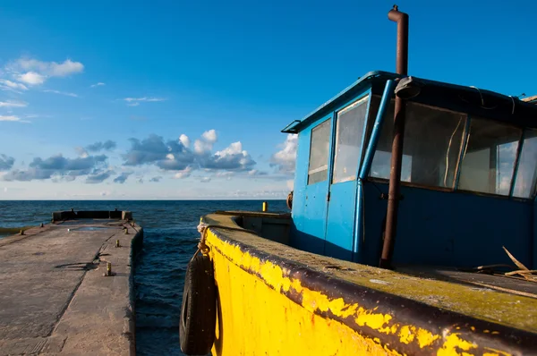 Gele vissersboot afgemeerd aan het strand — Stockfoto