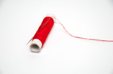 Kırmızı dikiş ipliği ve beyaz arka plan üzerinde izole iğne