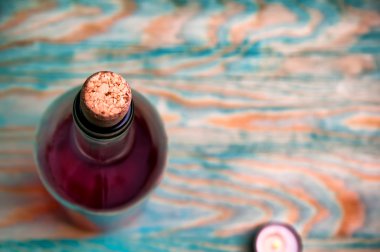 Şarap closeup mavi ahşap arka plan üzerinde yükseldi