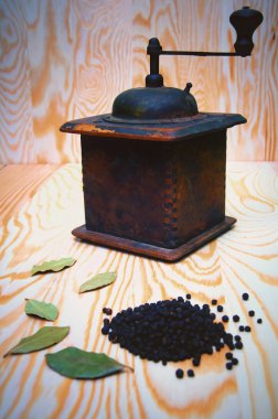 Vintage karabiber değirmeni ve ahşap arka plan üzerinde kuru baharat