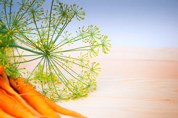 Porkkanat puupöydällä — kuvapankkivalokuva