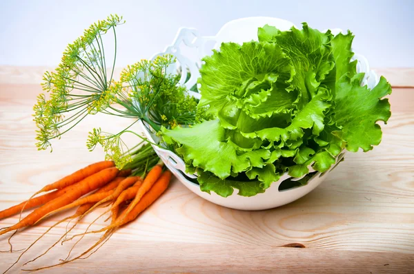 Gulrøtter, salat og fennikel på trebord – stockfoto