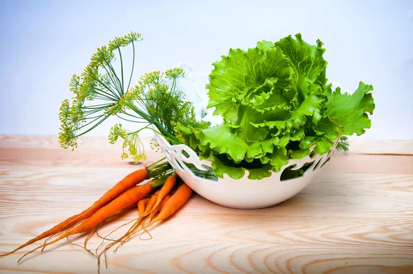 Gulrøtter, salat og fennikel på trebord – stockfoto