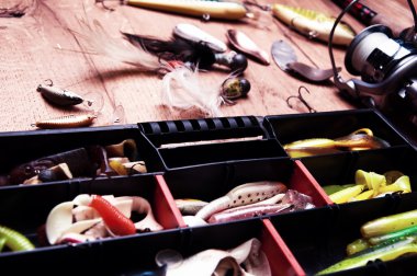 Balık tutma Yemler ve ahşap arka plan üzerinde izole çubuk