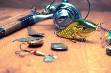 Balık tutma Yemler ve ahşap arka plan üzerinde izole çubuk