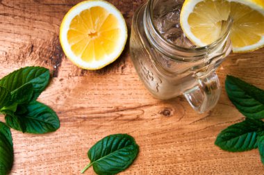Ahşap arka plan üzerinde soğuk taze limonata içmek