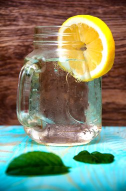 Ahşap arka plan üzerinde soğuk taze limonata içmek ve buz küpleri