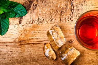 Ahşap arka plan üzerinde soğuk alkol içki ve buz küpleri