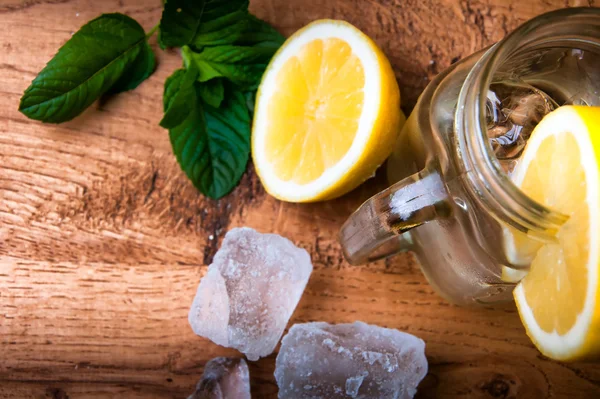 Холодний свіжий лимонадний напій і кубики льоду на дерев'яному фоні — стокове фото
