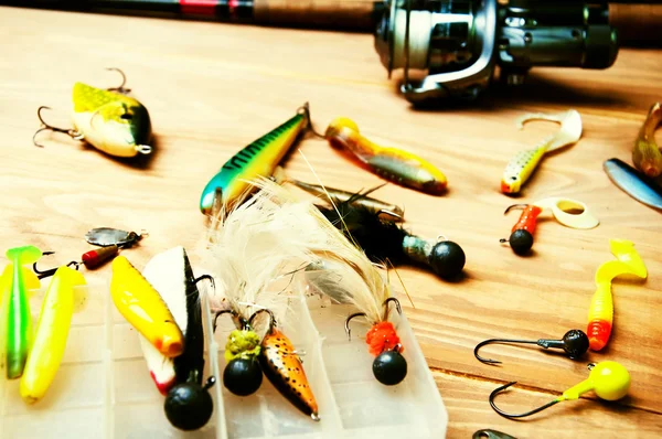 Balık tutma Yemler ve ahşap arka plan üzerinde izole çubuk